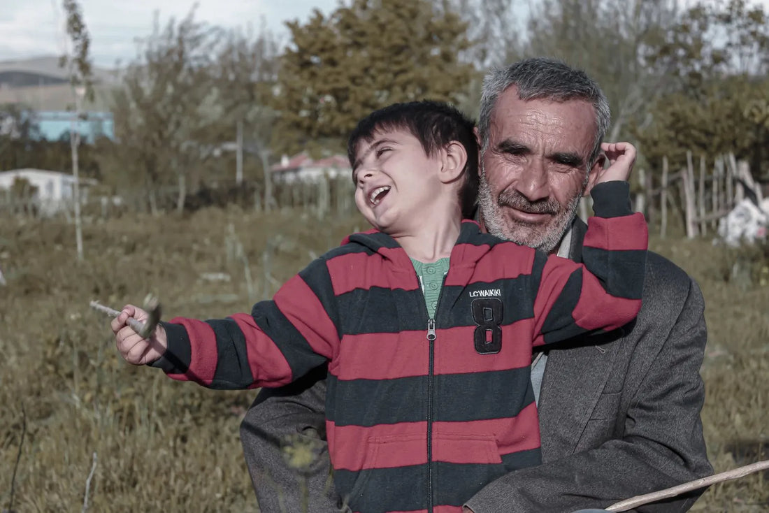 Un grand-père et son petit-fils rient ensemble dans un jardin