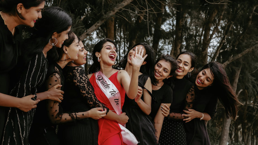 Future mariée entourée de ses amies souriantes, cadeau EVJF original en plein air
