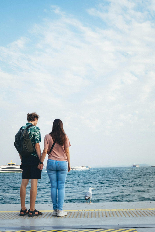 Couple debout sur un ponton face à l'eau, offrir une expérience plutôt qu'un objet