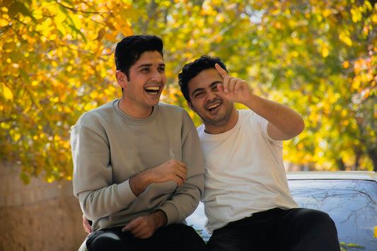 Deux hommes assis côte à côte, complicité pour un cadeau entre meilleurs amis hommes