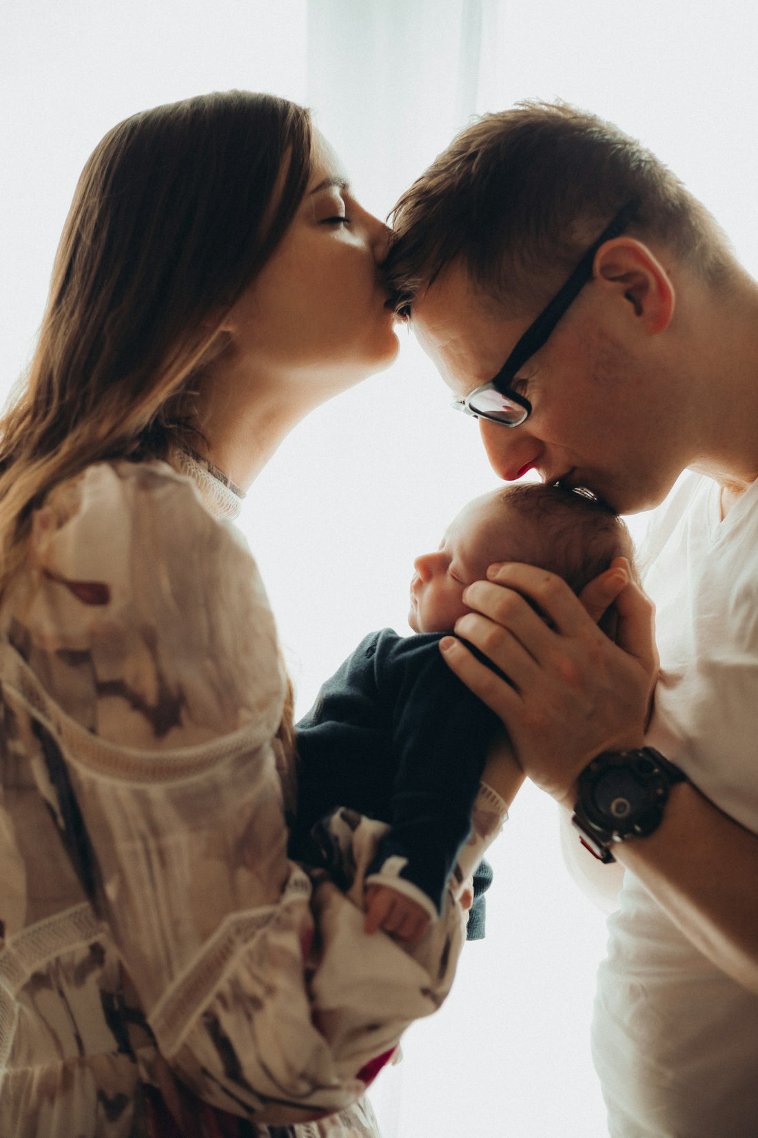 Parrain et marraine embrassant un bébé, cadeau symbolique pour parrain et marraine
